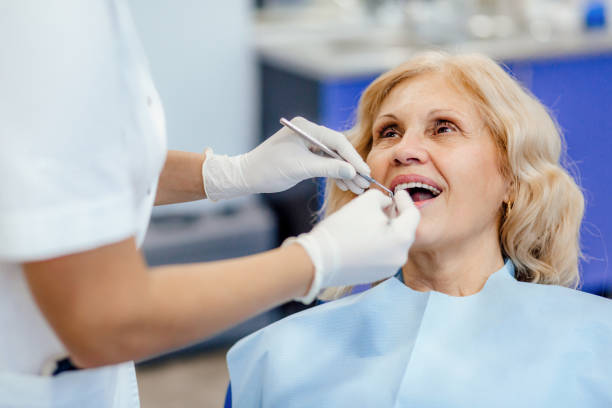 young but experienced dentist taking care of her elderly patient