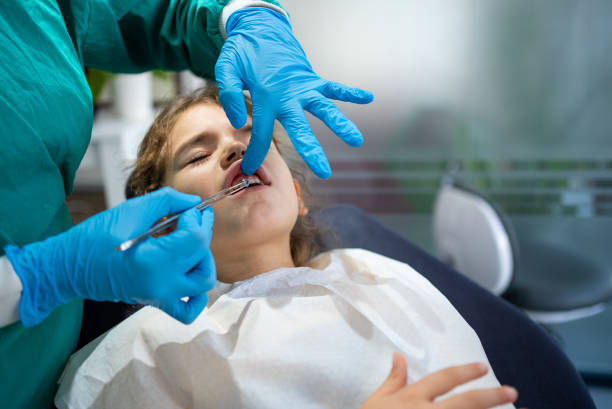 dentist checking a little girl s tooth